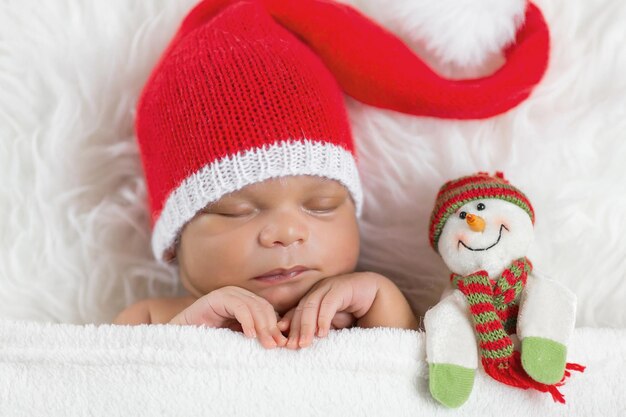 Sleeper newborn baby in a Christmas Santa cap