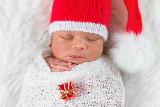 Sleeper newborn baby in a Christmas Santa cap