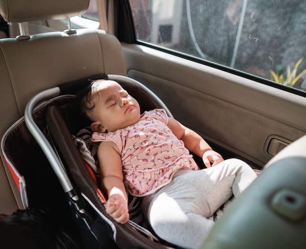 Sleeping baby sitting in the car chair