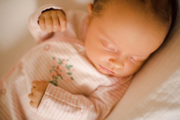 Sleeping infant baby wear pajamas lying in crib over white blanket at home in bedroom Child has nap