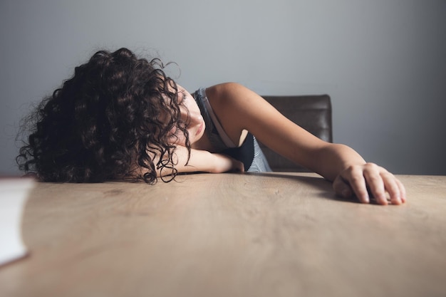 Sleeping tired woman on table