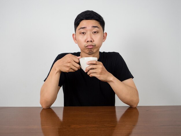 Sleepless man wake up at morning hold coffee cup in hand feels sleepy