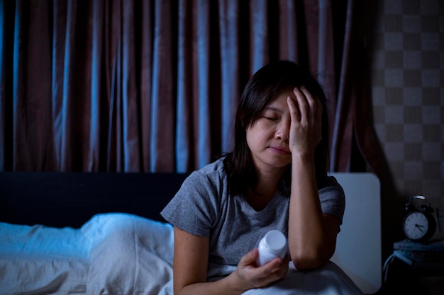 Sleeplessness Asian woman holding drug.Scared stressed thinking.Unhappy after can not sleep.Depression adult worry about her life.