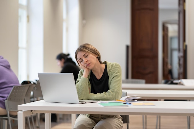 Sleepy bored middleaged woman mature student falling asleep during boring online class