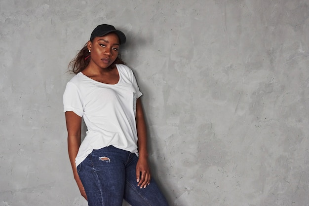 Sleepy and tired. Young beautiful african american woman  standing against grey space