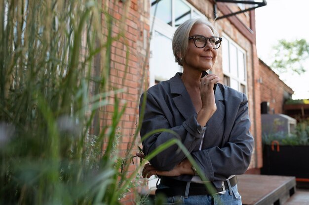 Photo a slender european grayhaired senior business woman with a stylish hairstyle and glasses is dressed