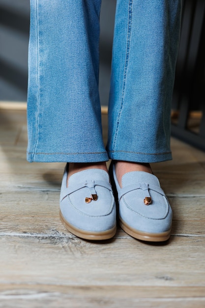 Slender female legs in jeans and blue loafers Collection of summer women's shoes Stylish women's shoes for summer