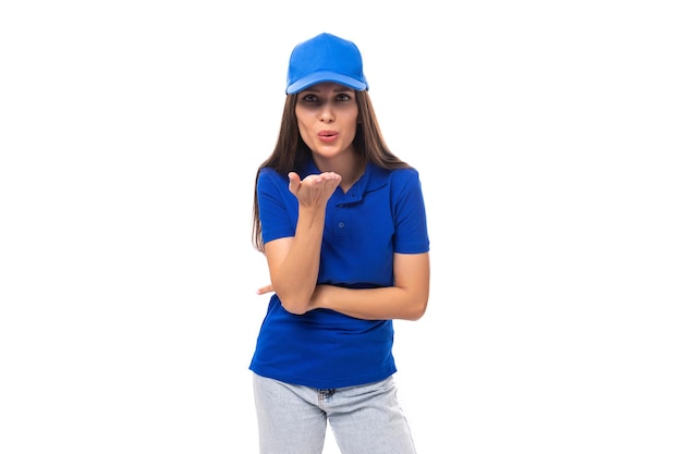 Slender pretty young caucasian brunette advertiser woman in blank blue tshirt and cap for print