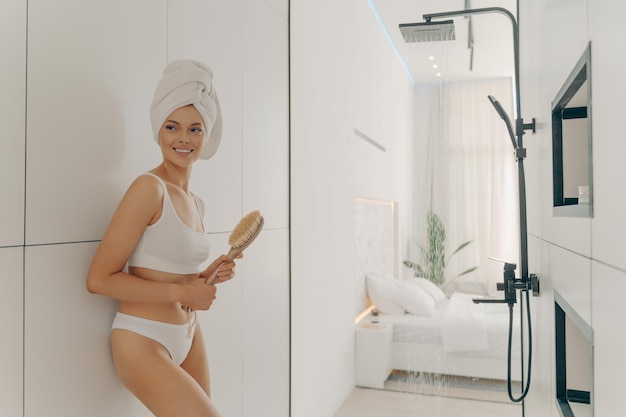 Slender young female model posing with head wrapped in white towel