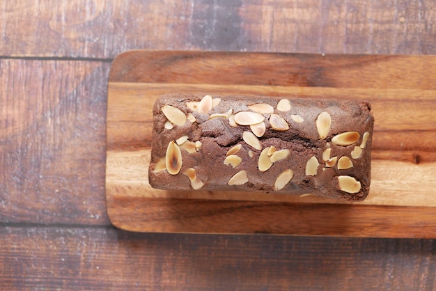 Slice of bakery fruit cake on chopping board