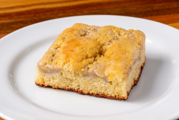 Slice of banana cake on a white plate on a wooden table