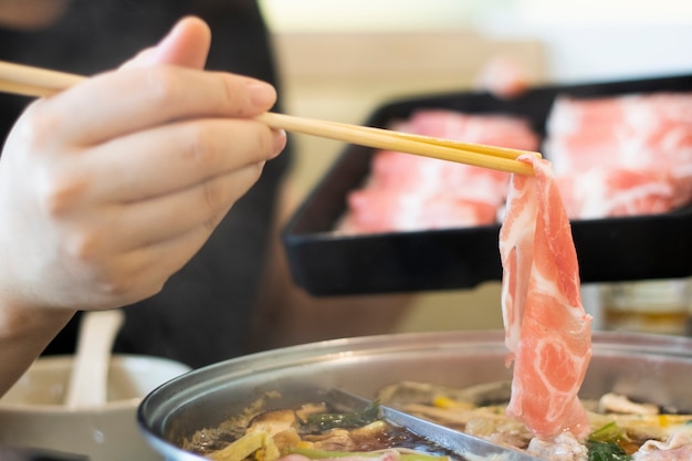 Slice beef on chopsticks cook shabu food