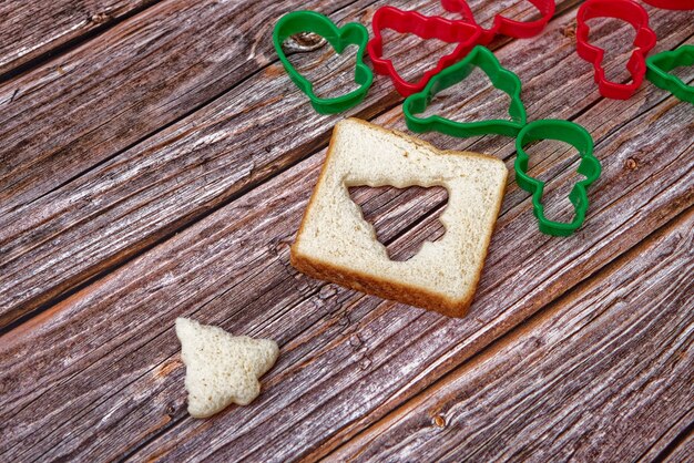 Slice of bread cut into the shape of a christmas tree on wooden table