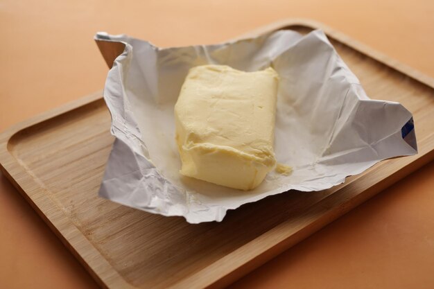 Slice of a butter on a paper on table