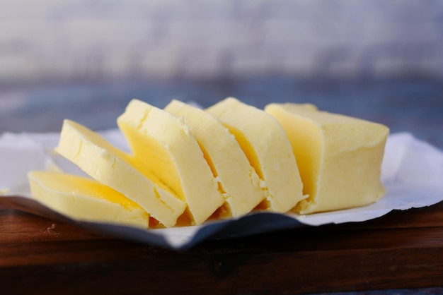 slice of a butter on a paper on table .