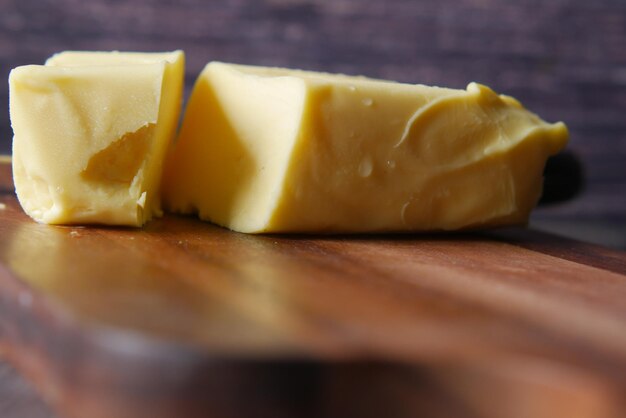 Slice of a butter on a paper on table