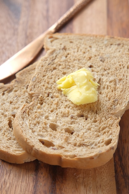 Slice of butter and whole meal bread on chopping board