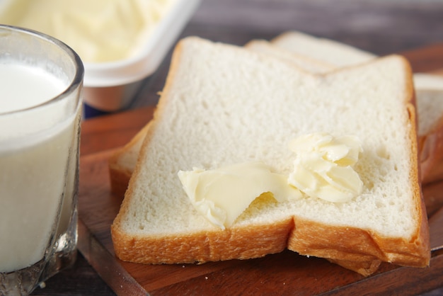 Slice of butter and whole meal bread on chopping board