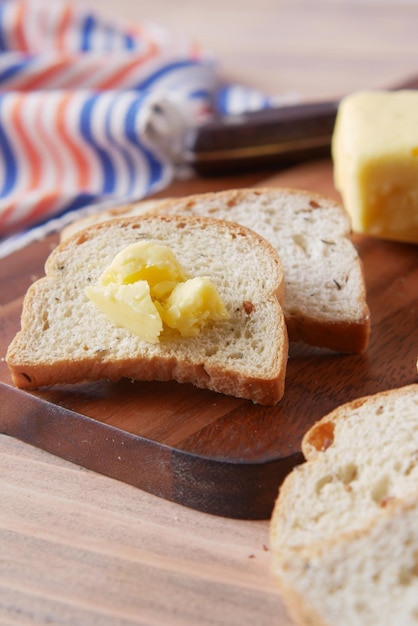 Slice of butter and whole meal bread on chopping board