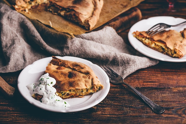 Slice of cabbage pie with sour cream sauce