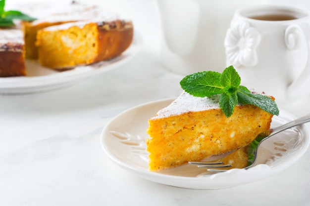 Slice cheese casserole with pumpkin and cinnamon for breakfast on ceramic plate  on a light table. Selective focus.