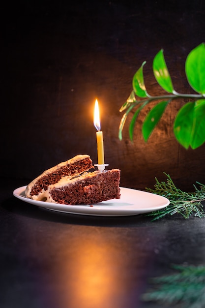 Slice of a chocolate cake with a candle