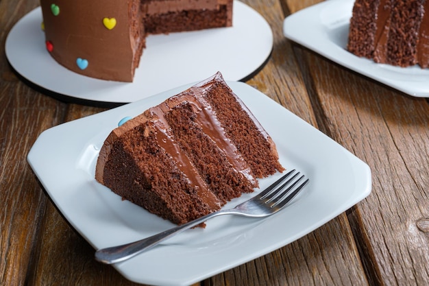 Slice of chocolate cake with filling and semisweet chocolate ganache frosting