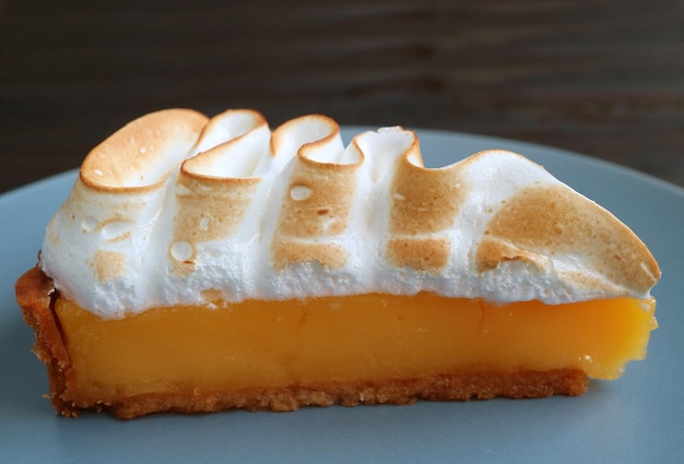 Slice of Delectable Lemon Meringue Tart on a Blue Plate