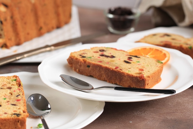 Slice of Delicious Homemade English Fruit Cake Loaf Pudding with Dried Mixed Fruit, Sultanas, Raisins, and Chopped Almond. Served during Christmas Party or New Year Eve