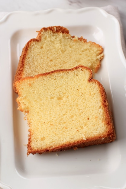 Slice of Fluffly Vanilla Chiffon Cake or Sponge Cake on Wooden Plate, Served with Tea and Honey