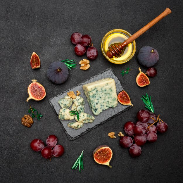 Slice of French Roquefort cheese and fruits on stone board