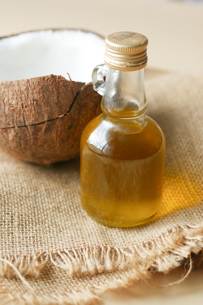 Slice of fresh coconut and bottle of oil on a table