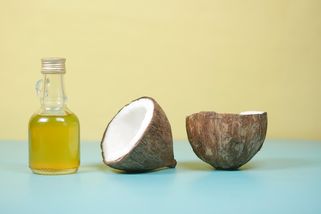 Slice of fresh coconut and bottle of oil on a table