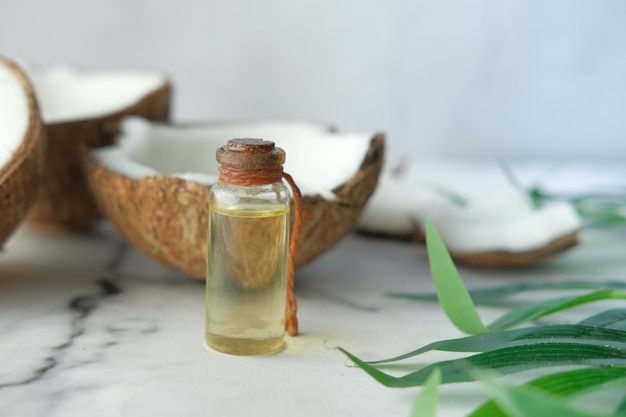 Slice of fresh coconut and bottle of oil on a table