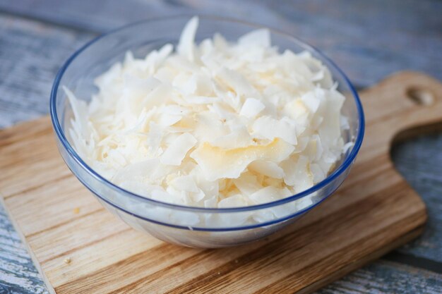 Slice of fresh coconut flakes in a bowl on a table