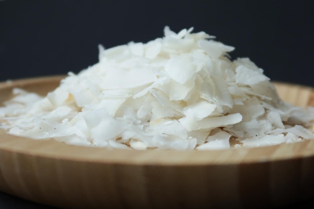 Slice of fresh coconut flakes in a bowl on a table