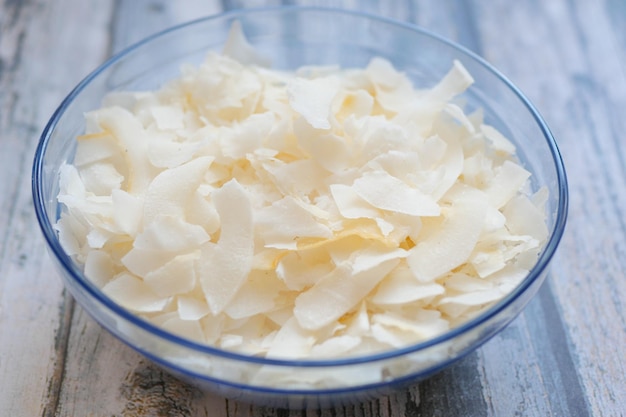 Slice of fresh coconut flakes in a bowl on a table