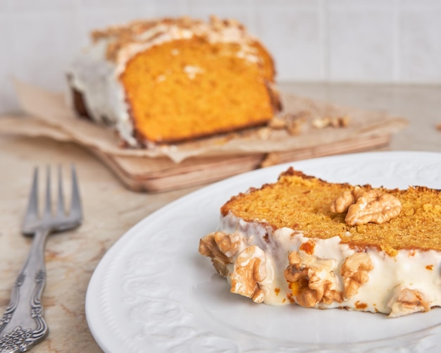 Slice of homemade carrot cake with sugar frosting and nuts Food concept