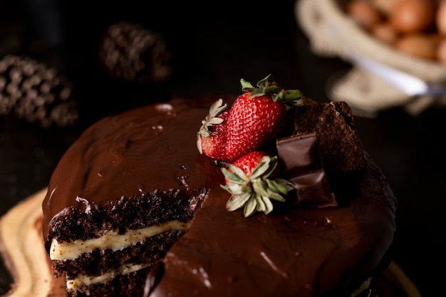 Slice of homemade chocolate cake with tasty strawberry on the table