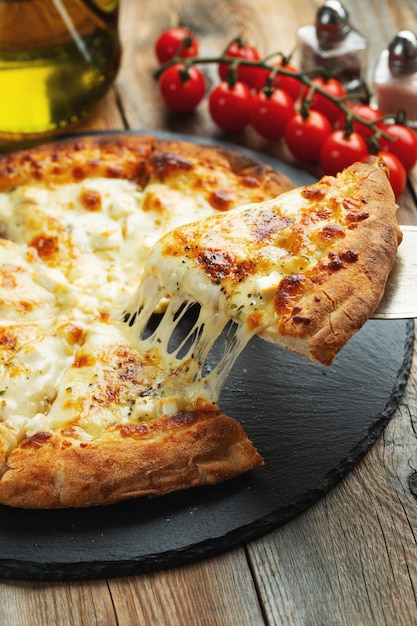 A slice of hot Italian pizza with stretching cheese Pizza four cheeses with basil