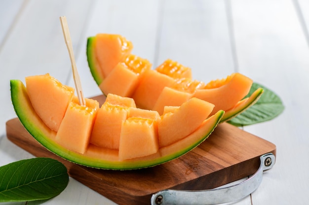 Slice of japanese melons orange melon or cantaloupe melon on white wood background