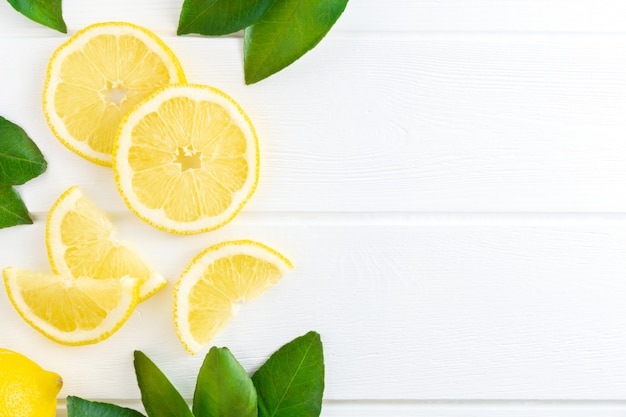 Slice of lemon and green leaves background