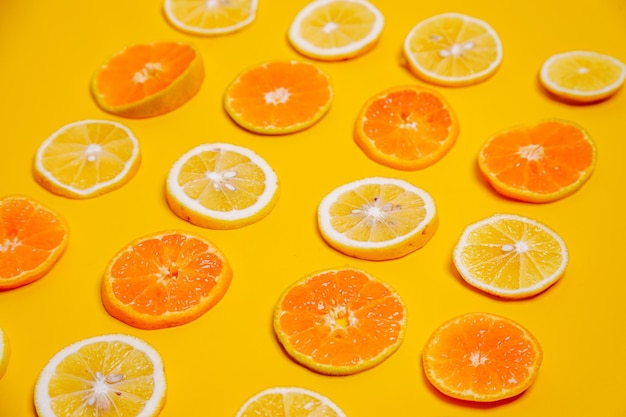 Slice of lemon and orange fruits on yellow background Cute wallpaper for summer healthy drink