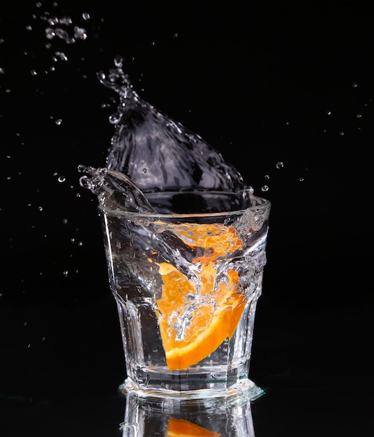 Slice of lemon splashing into a glass of water