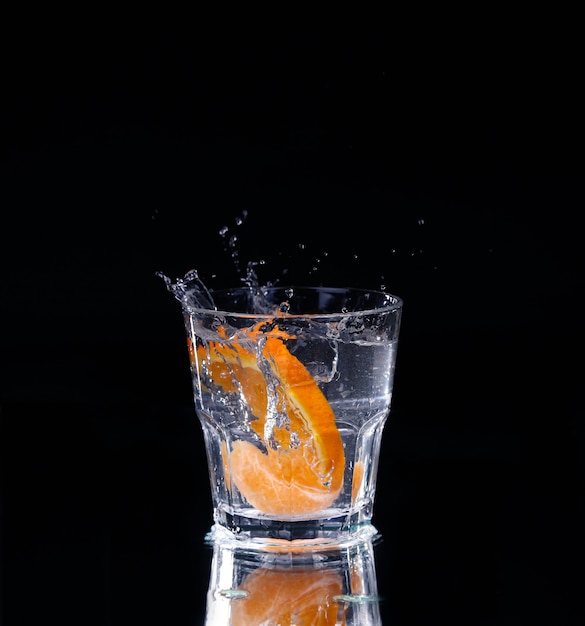 Slice of lemon splashing into a glass of water