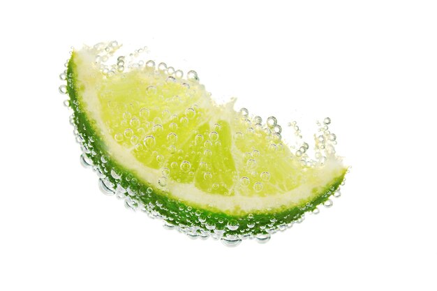 Slice of lime in the water with bubbles