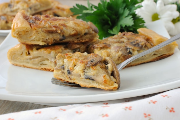 Slice of pie with mushrooms and cream sauce on a fork