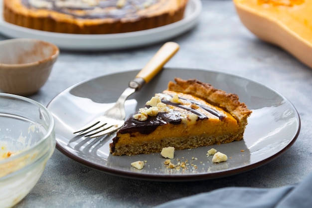 Slice of pumpkin pie. Top view of squash tart. Homemade autumn food. Bakery background