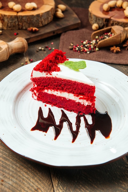 Slice of red velvet cake decorated with chocolate sauce