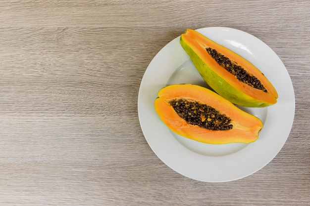 Photo slice of ripe papayas on wooden table with vintage and vignette, healthy fruit